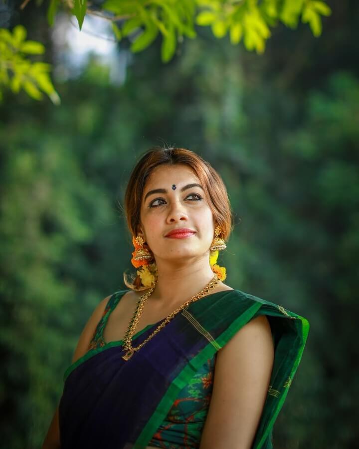Dilsha Prasannan close up shot in dark green saree and sleeveless blouse