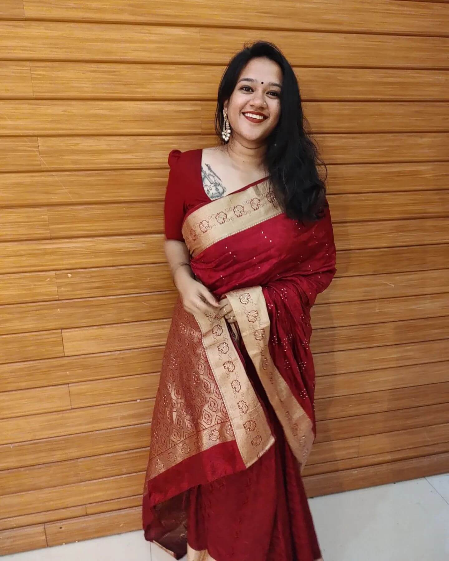Actress Lakshmi Menon in dark red and golden border saree