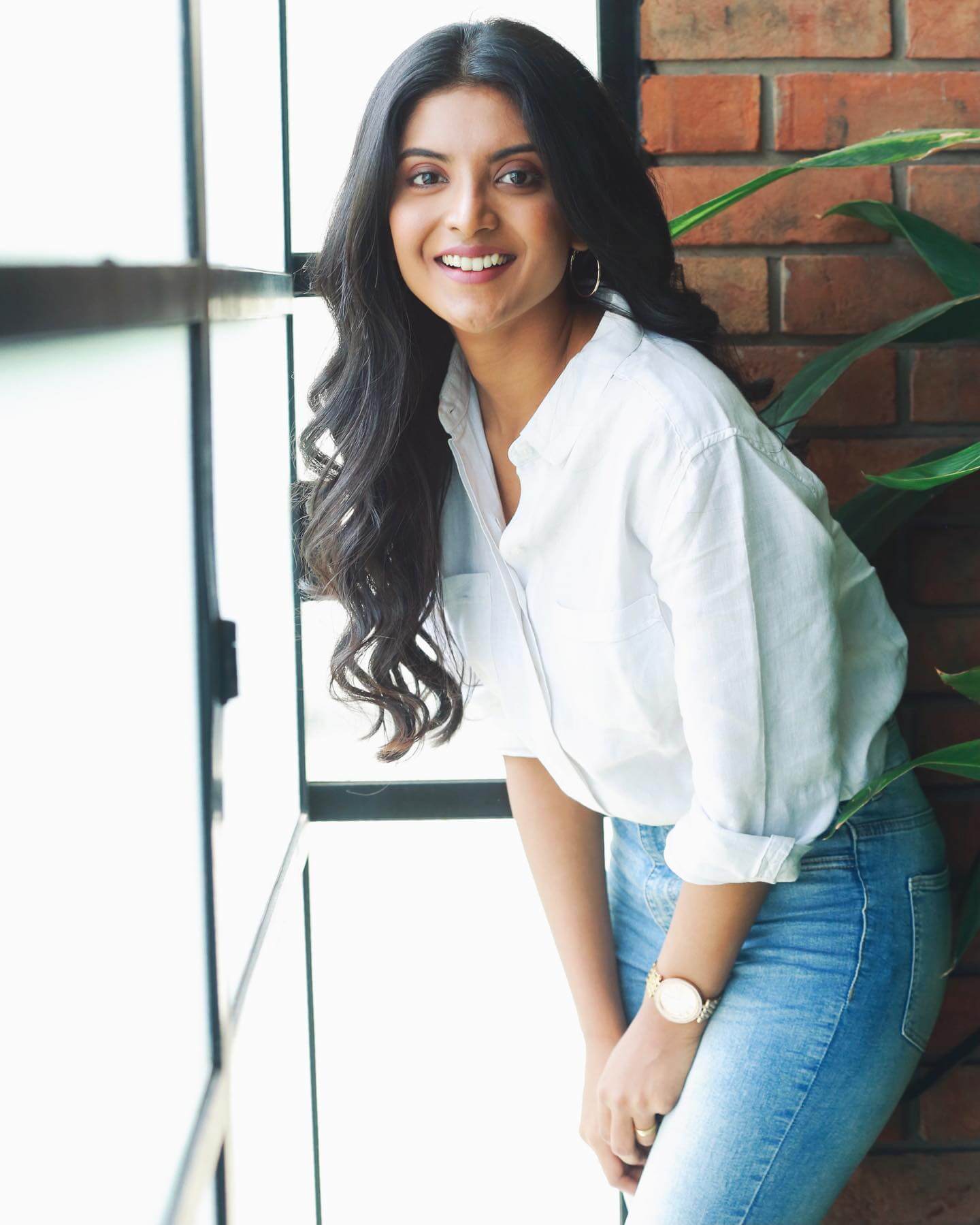 Actress Nivedhithaa Sathish in white shirt and blue jeans
