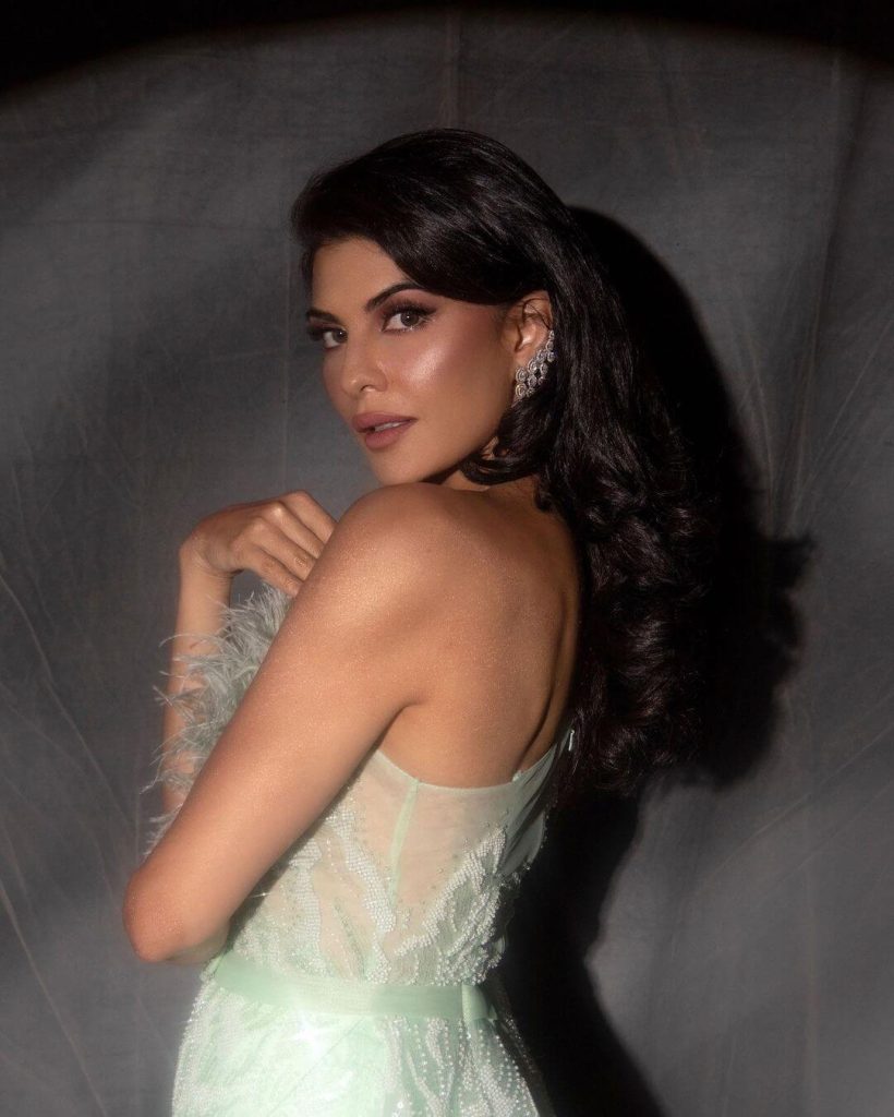 Actress Jacqueline Fernandez in tea-green thigh-high slit gown paired with a pair of beautiful drop diamond earrings