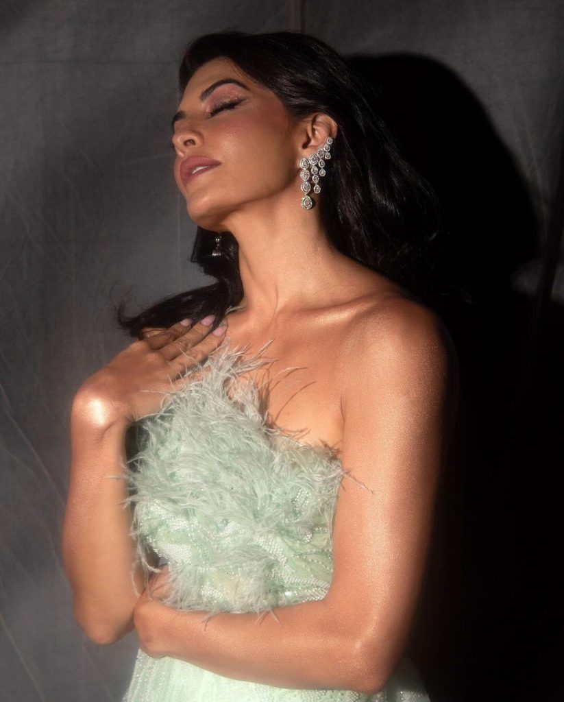 Actress Jacqueline Fernandez in tea-green thigh-high slit gown paired with a pair of beautiful drop diamond earrings